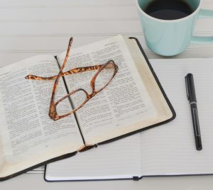 flat lay photography of tortoiseshell eyeglasses on top of book near black pen and teal mug