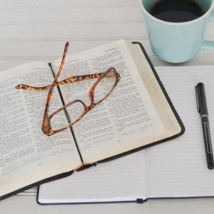 flat lay photography of tortoiseshell eyeglasses on top of book near black pen and teal mug