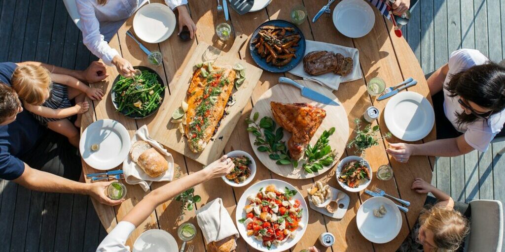 people eating on table with foods